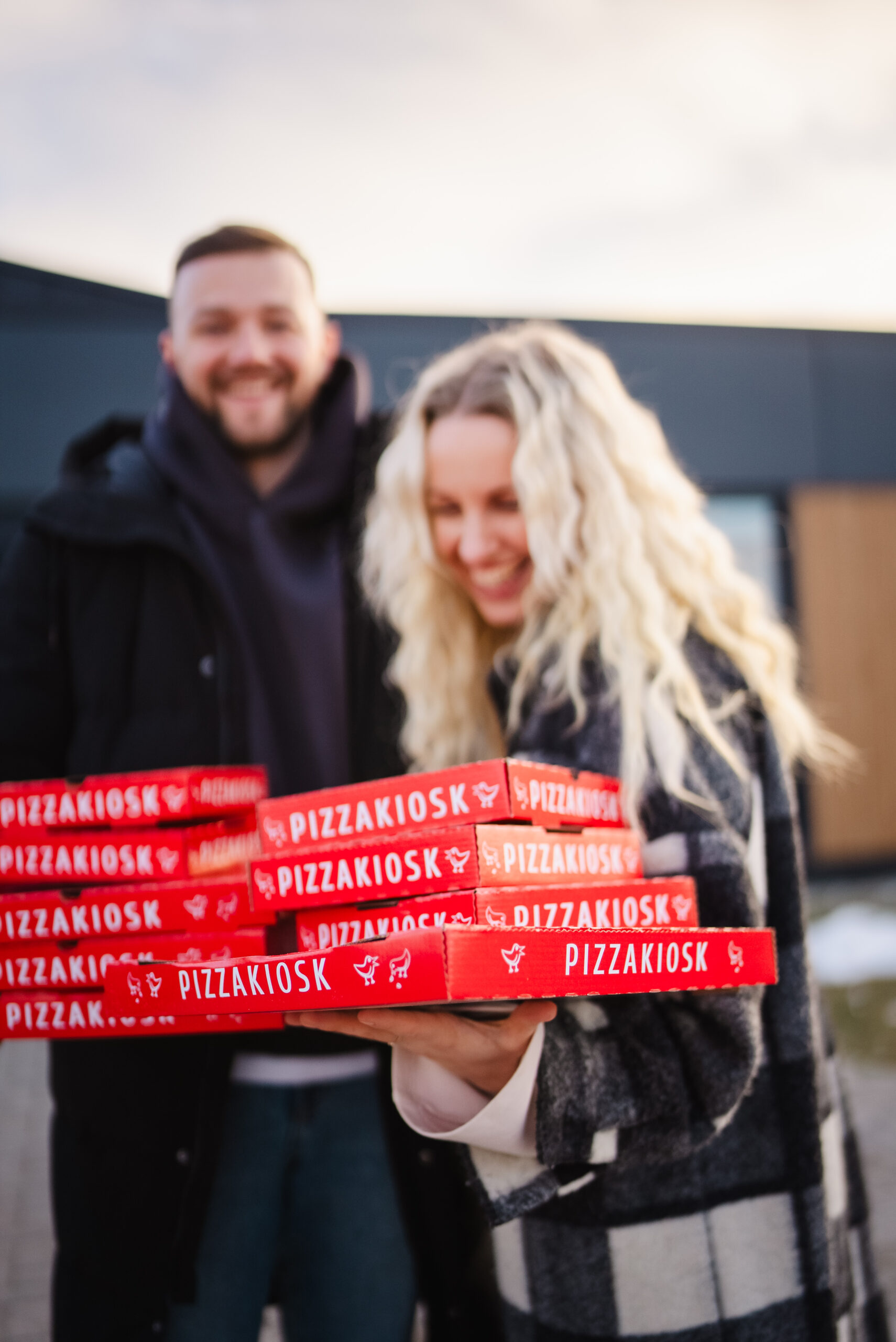 Inimesed hoiavad käes Pizzakioski karpe ja naeravad