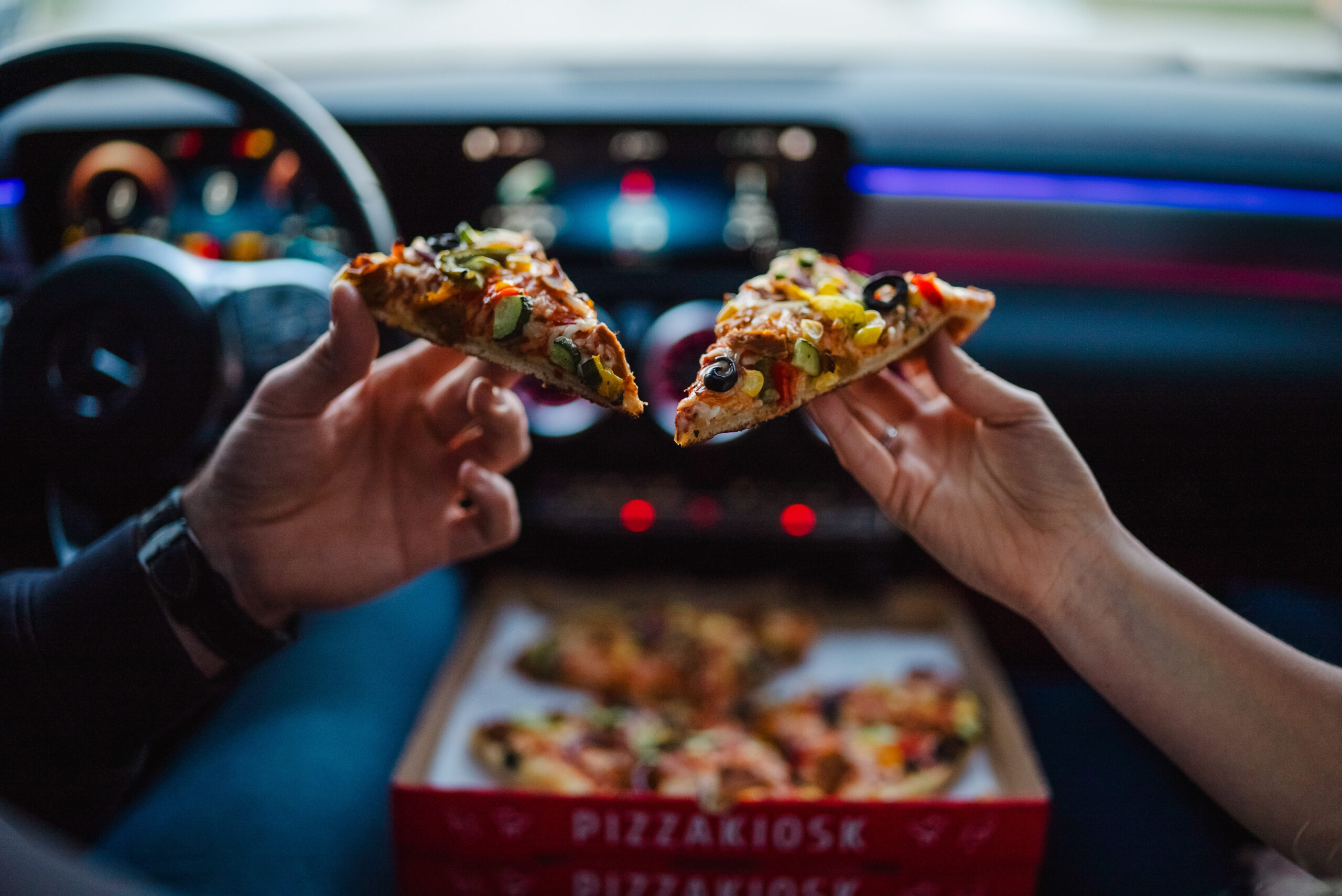 Kaks inimest söövad autos pitsat Pizzakiosk